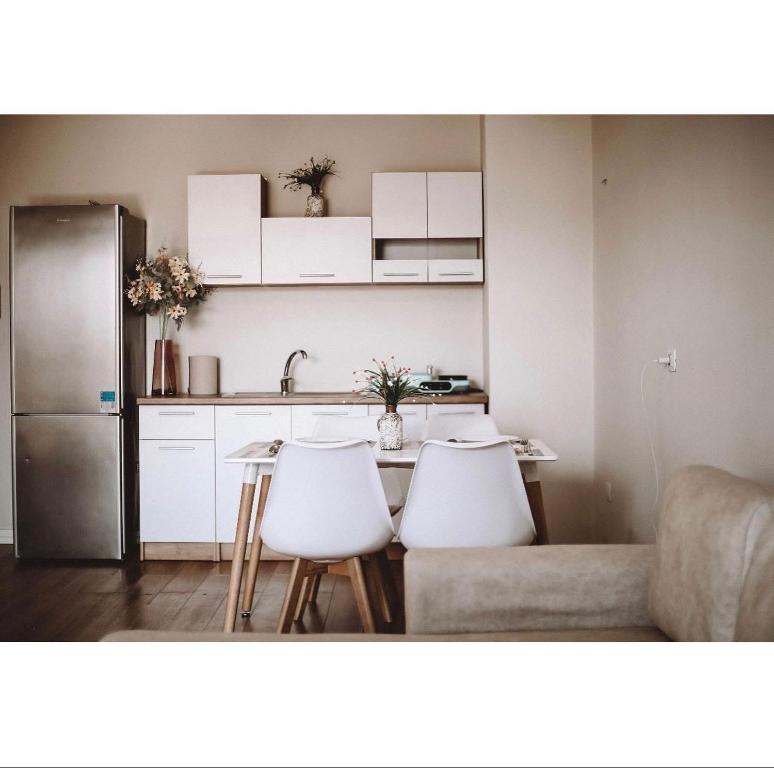 a kitchen with a table and chairs and a refrigerator at Kalpazo Tirana Mosaic in Tirana
