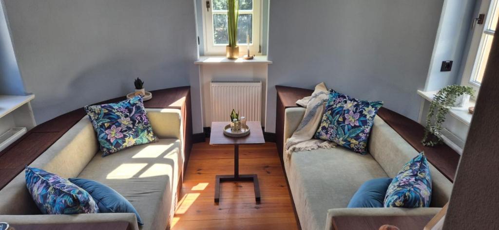 a living room with two couches and a table at Schlosshotel Hohenbocka in Hohenbocka