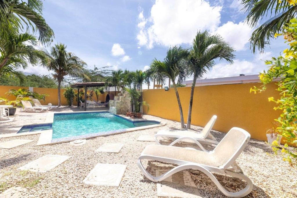 a swimming pool with two lounge chairs next to a building at Casa Trankilo - Family Home in Paraguaná