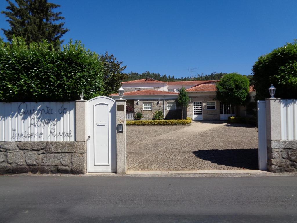 dom z białą bramą i podjazdem w obiekcie Quinta Do Alves w mieście Paços de Ferreira