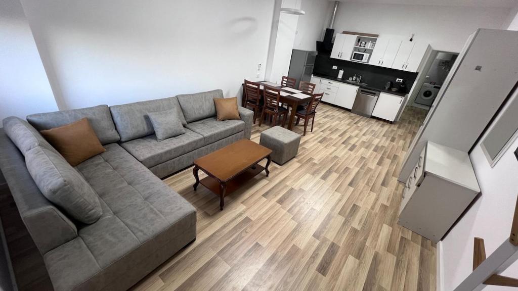 a living room with a couch and a kitchen at Palita Vita - Durrës Beach in Durrës