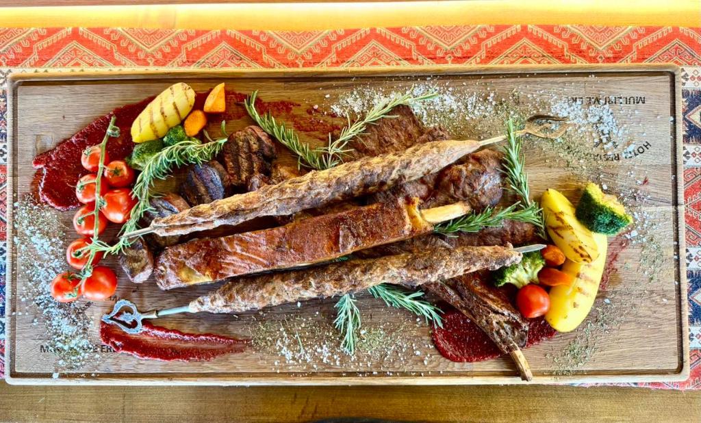 a tray of food with meat and vegetables on a table at Hotel & Restaurant Mulliri me Erë in Rahovec