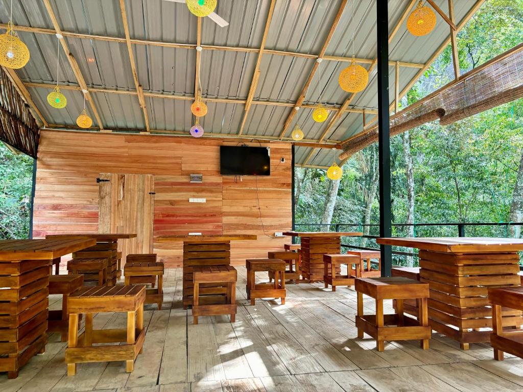 a restaurant with wooden tables and chairs and a flat screen tv at Riverston Water Front Villa in Rattota