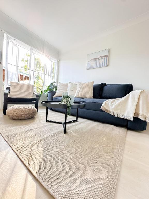 a living room with a blue couch and a table at Mi Casa Su Casa - 2BR Sleeps 6 - Free Parking - CBD in Brisbane