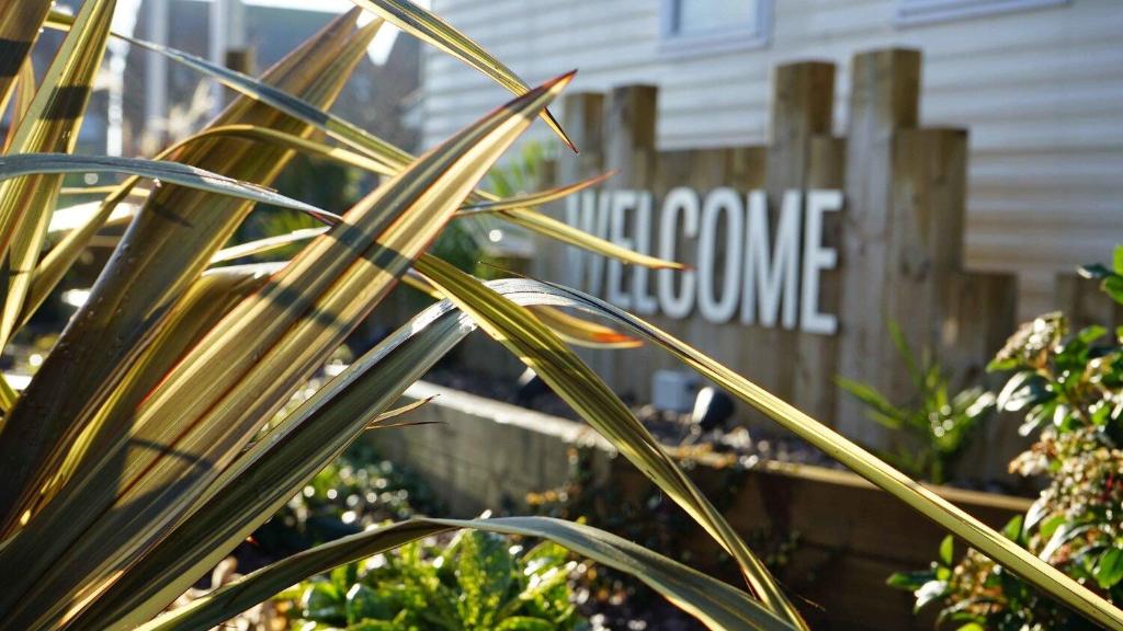 a plant in front of a house with a fence at Mablethorpe Static Holiday Home in Mablethorpe