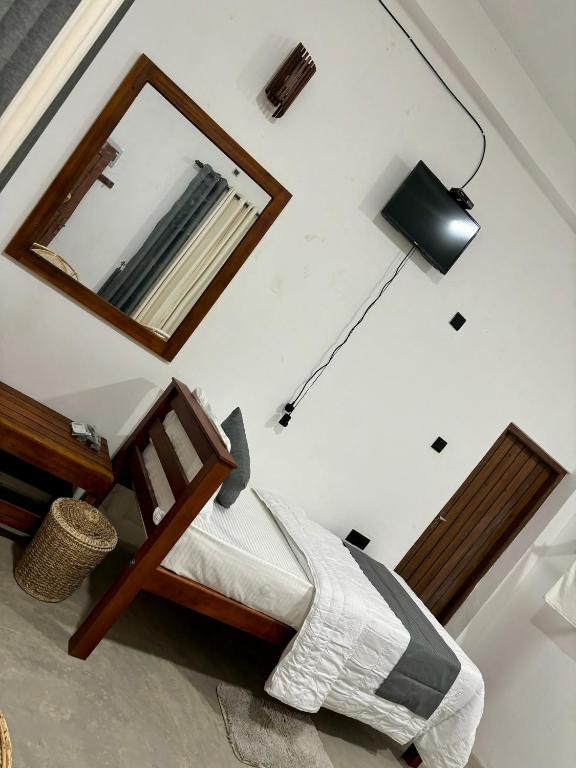 a bedroom with a bed with a mirror and a lamp at Riverston Water Front Villa in Rattota