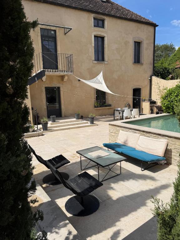 a patio with a table and chairs and a pool at Pommard Clos in Pommard