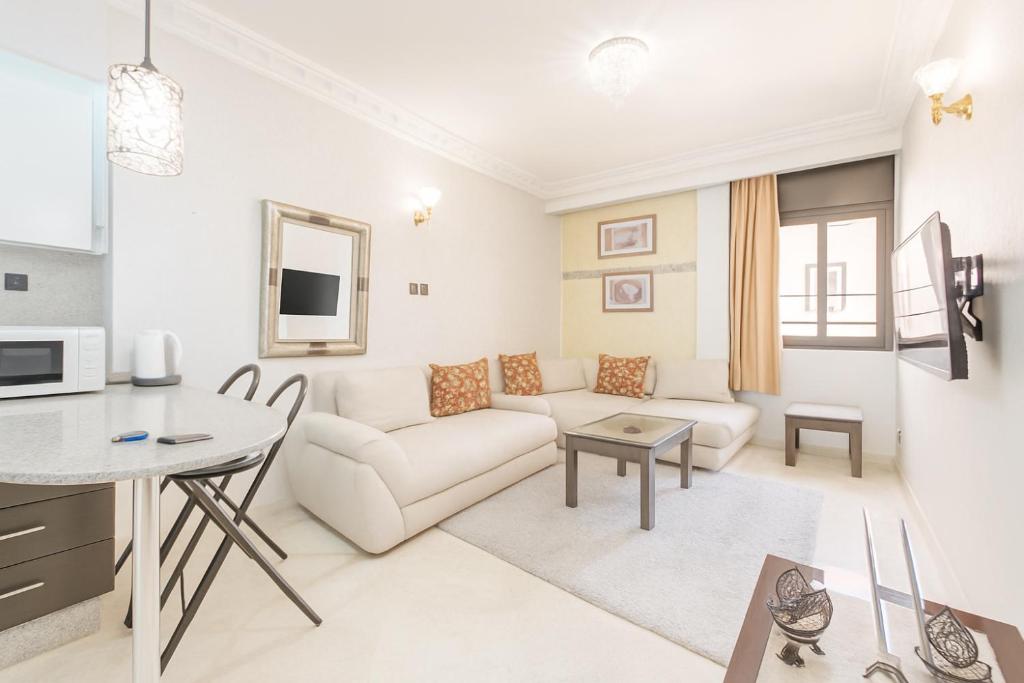 a white living room with a couch and a table at Sabor Apartment Anas Majorelle in Marrakech