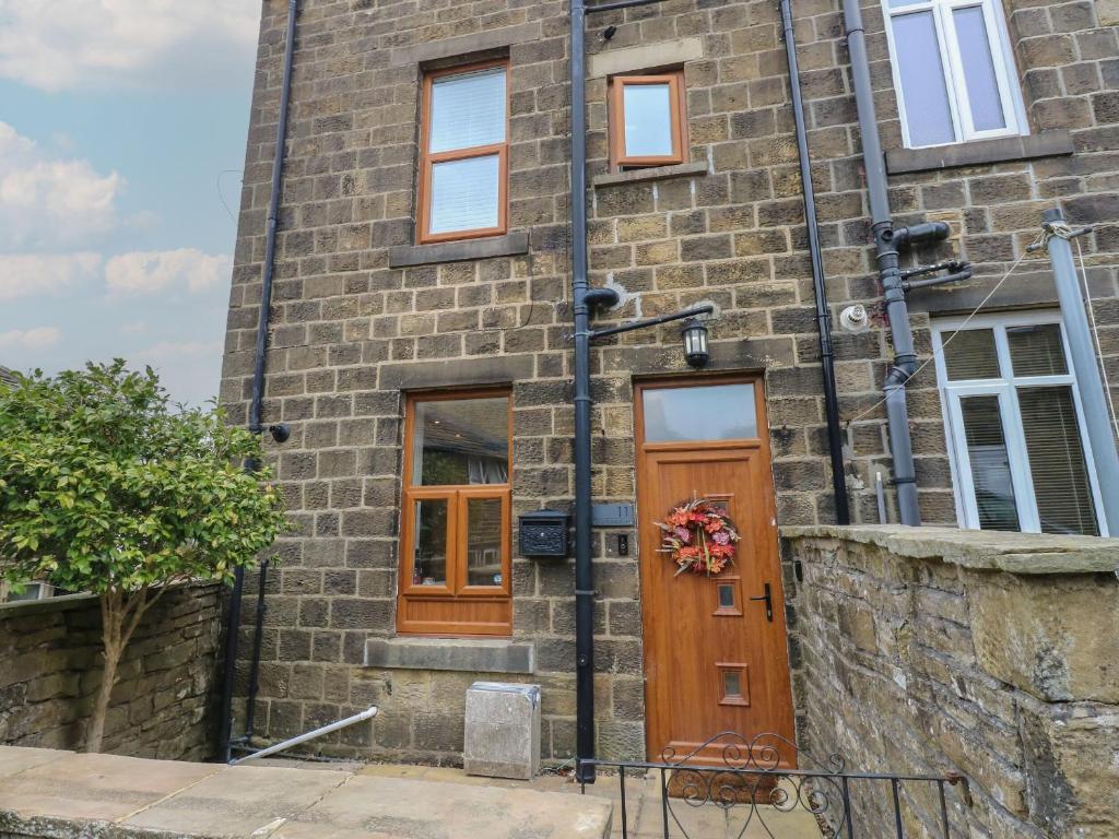 un edificio de ladrillo con puertas y ventanas de madera en 11 Bronte Street, en Haworth