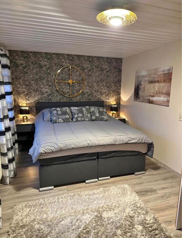 a bedroom with a bed with a large clock on the wall at Cozy City Apartment in Kaiserslautern