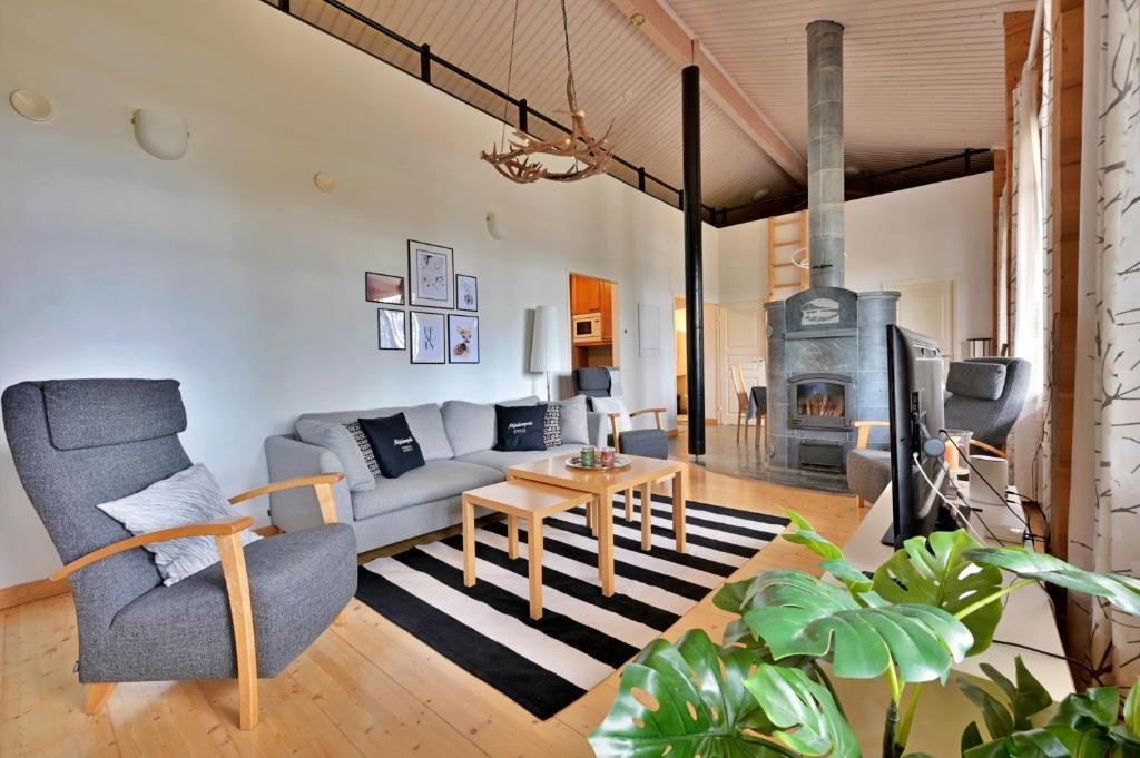 un soggiorno con divano e camino di Holiday Cabin Isomus inc outdoor jacuzzi ad Äkäslompolo