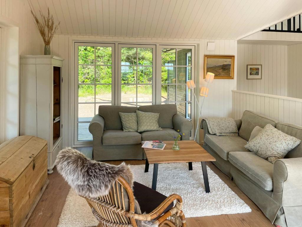 a living room with a couch and a table at Lovely Black Wooden House Near Tisvilde Hegn in Tisvilde