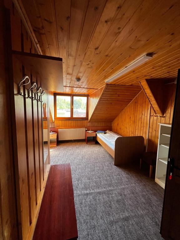 a large room with a bed in a wooden building at FELIX hostel in Dumbrăveni
