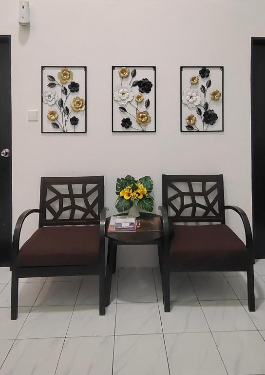 two chairs and a table with flowers on a wall at Tuaran 88 Homestay in Tuaran