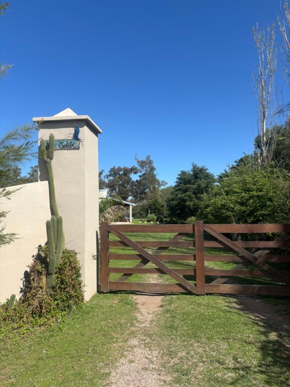 a wooden fence with a gate in the grass at El Colibrí Casa de Campo in Villa María