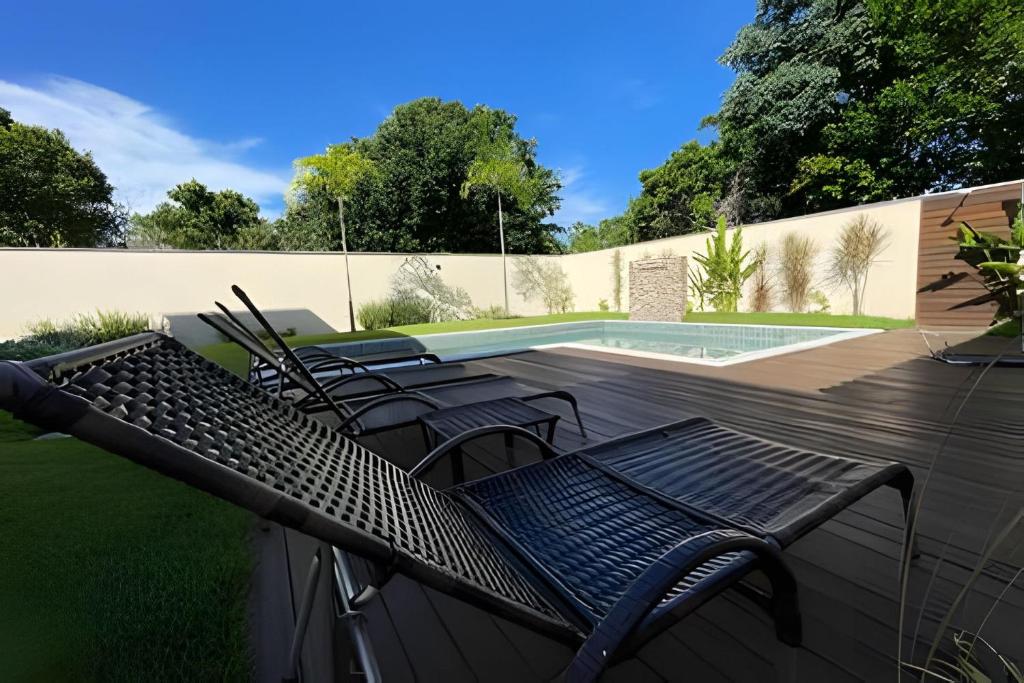 ポルト・セグロにあるCasa com Piscina a 5 min da Praia – 3 Quartos, A/Cのテニスコート近くのデッキに置かれた椅子のグループ