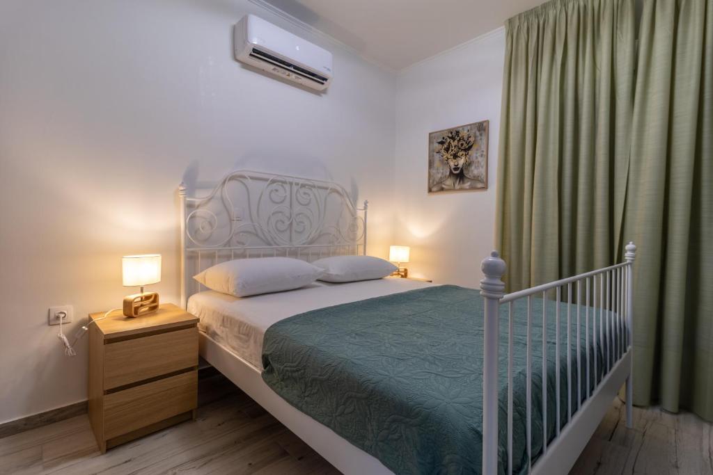 a bedroom with a bed and a green curtain at Modern Loutraki Apartment 3min Walk to Beach Fits 4 in Loutraki