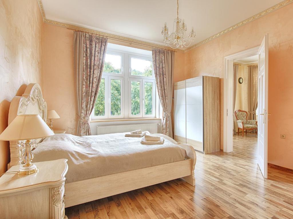 Un dormitorio con una cama grande y una ventana en Lyra Apartments, en Karlovy Vary