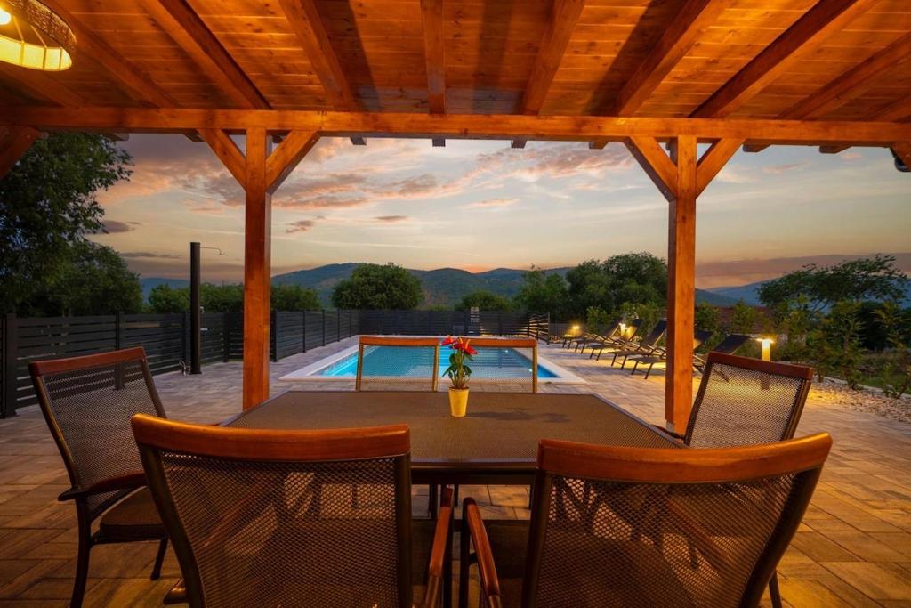 a patio with a table and chairs and a pool at KAPO Mobile Home in Sitno Donje
