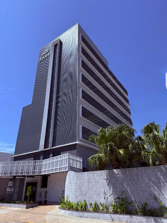 グアラティンゲタにあるLotus Hotel - à 6 km do Santuário de Aparecida-SPの前に看板がある高い建物