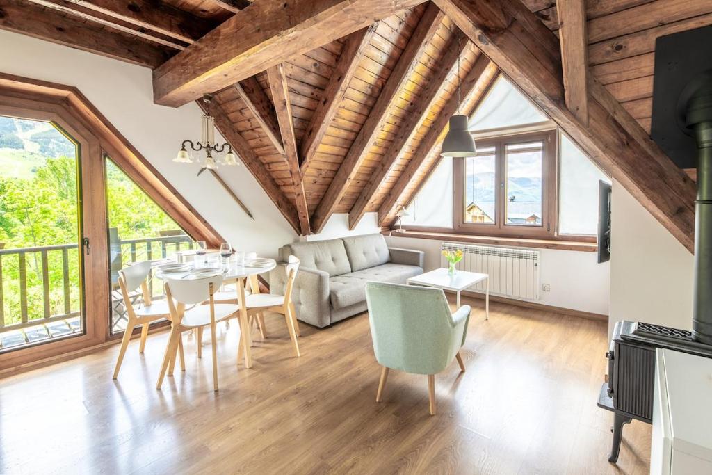 a living room with wooden ceilings and a table and chairs at Las casitas de mache - MODESTO in Cerler