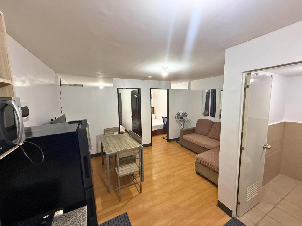 a living room with a couch and a table at 2-Bedroom Condo in Imus Cavite with UNLI WIFI, 50" TV, Netflix, Family Computer, Pool in Imus
