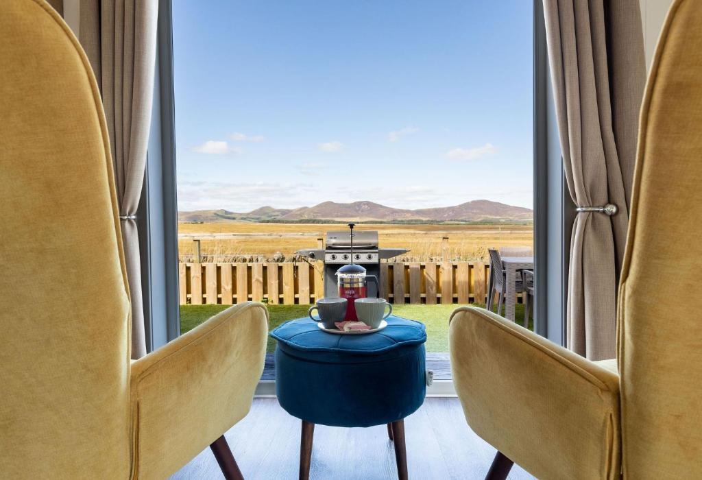 a room with a table and chairs and a window at South Black Hill in Penicuik