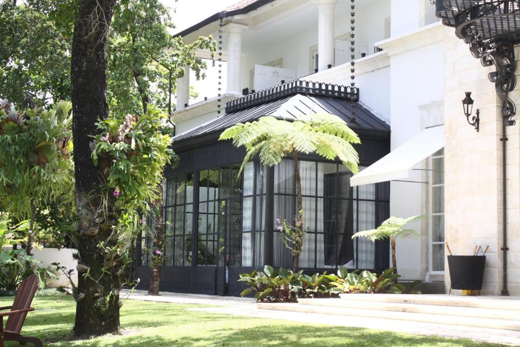 a building with black doors and a tree at Casa Colonial Beach & Spa in San Felipe de Puerto Plata