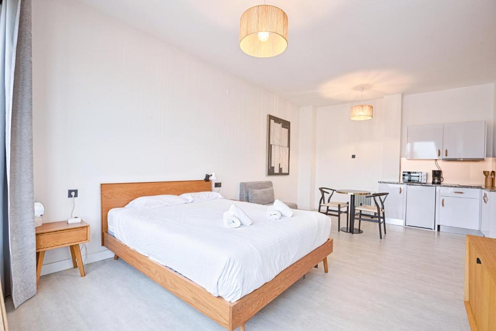 a bedroom with a large bed and a kitchen at Lindo apartamento Porto - Gaia in Vila Nova de Gaia