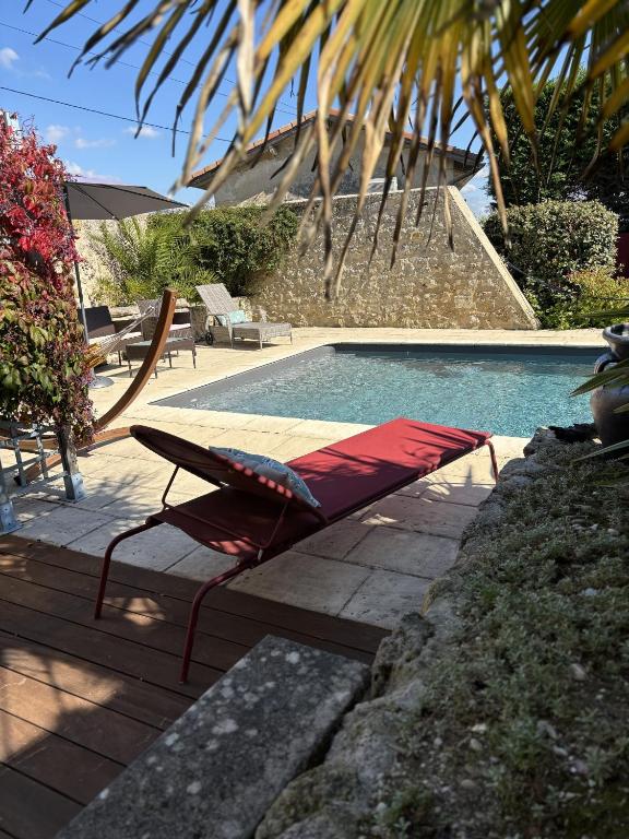 a swimming pool with a chaise lounger next to a pool at LA MAISON JEROBOAM in Saint-Estèphe
