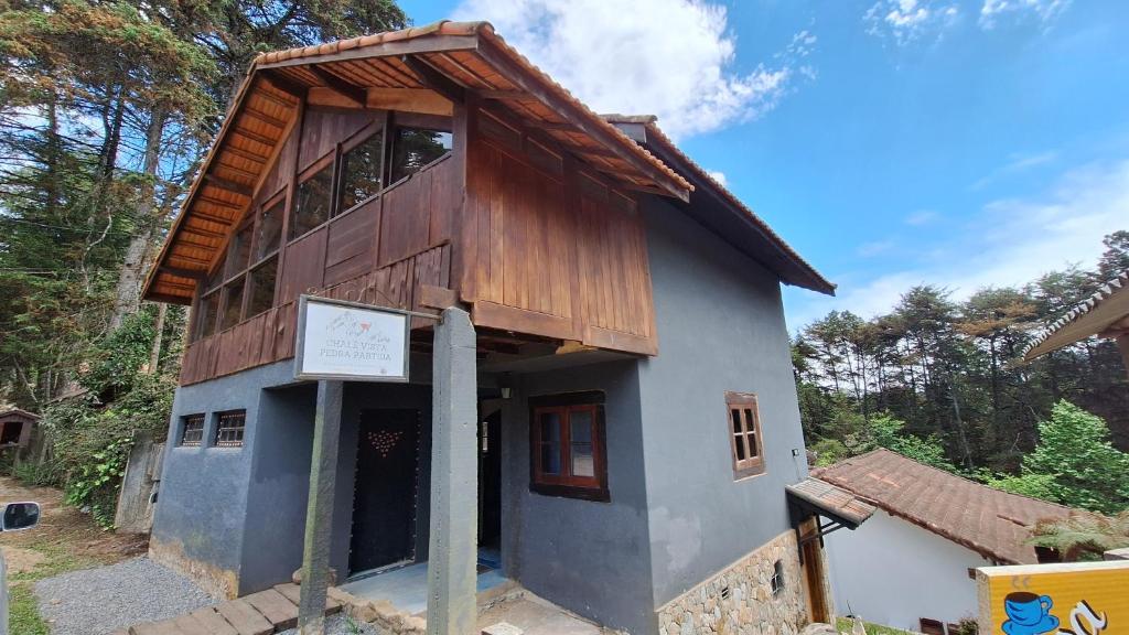 a small house with a wooden roof at Chalé Vista Pedra Partida in Monte Verde