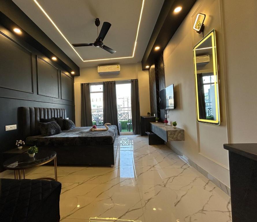 a bedroom with a bed and a television in a room at Elite BnB, High Rise with city view in Ghaziabad
