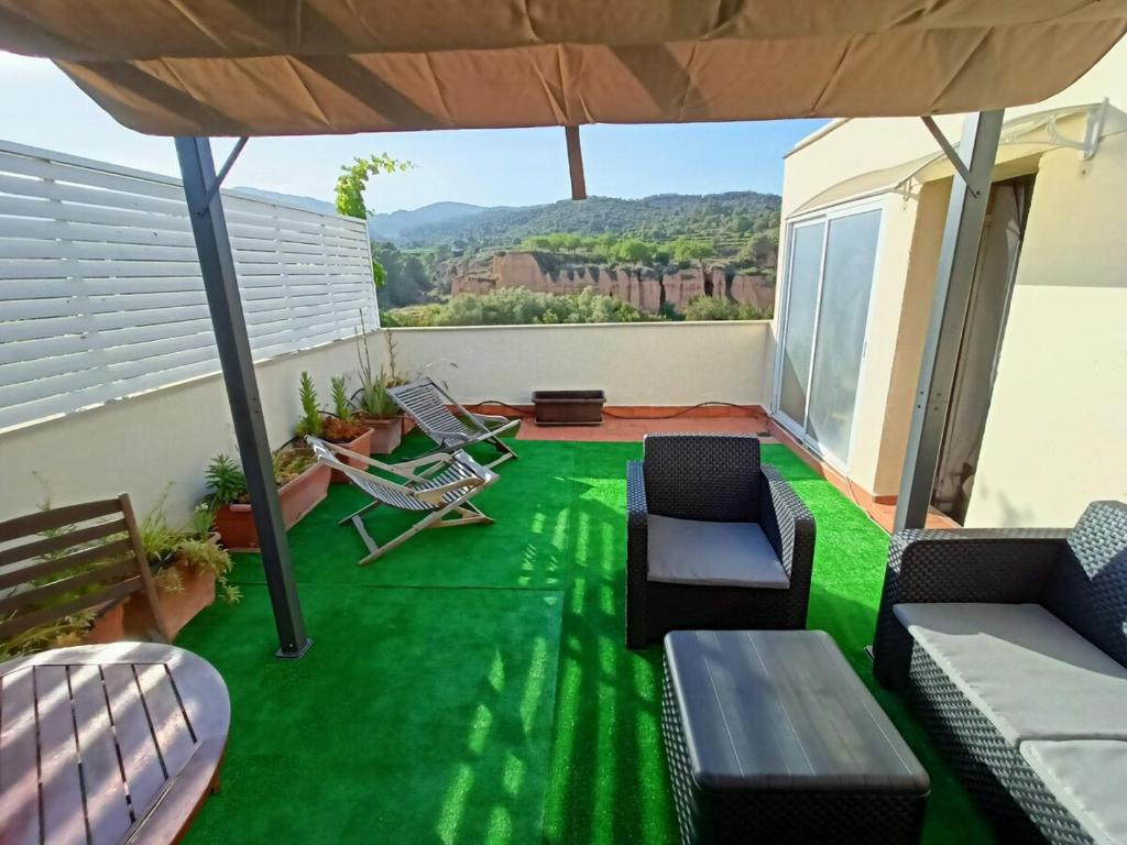 a patio with a green floor and furniture on it at La Cantonada in Sant Pere de Ribes