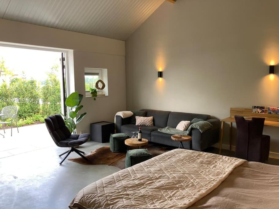 a living room with a bed and a couch at Weidezicht Soest rust en natuur in Soest