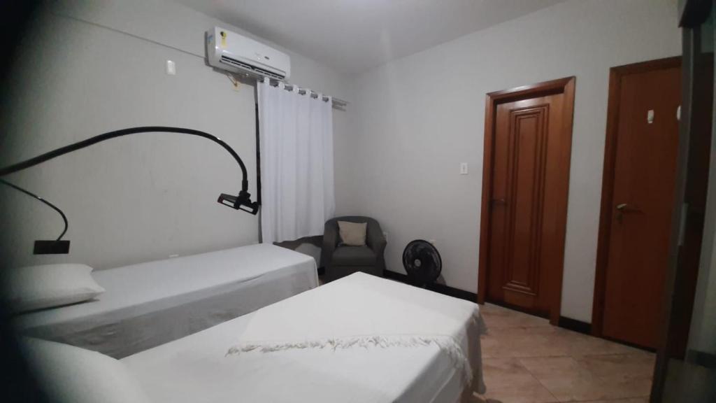 a small room with two beds and a door at Cozy Family Home - COP 30 in Belém