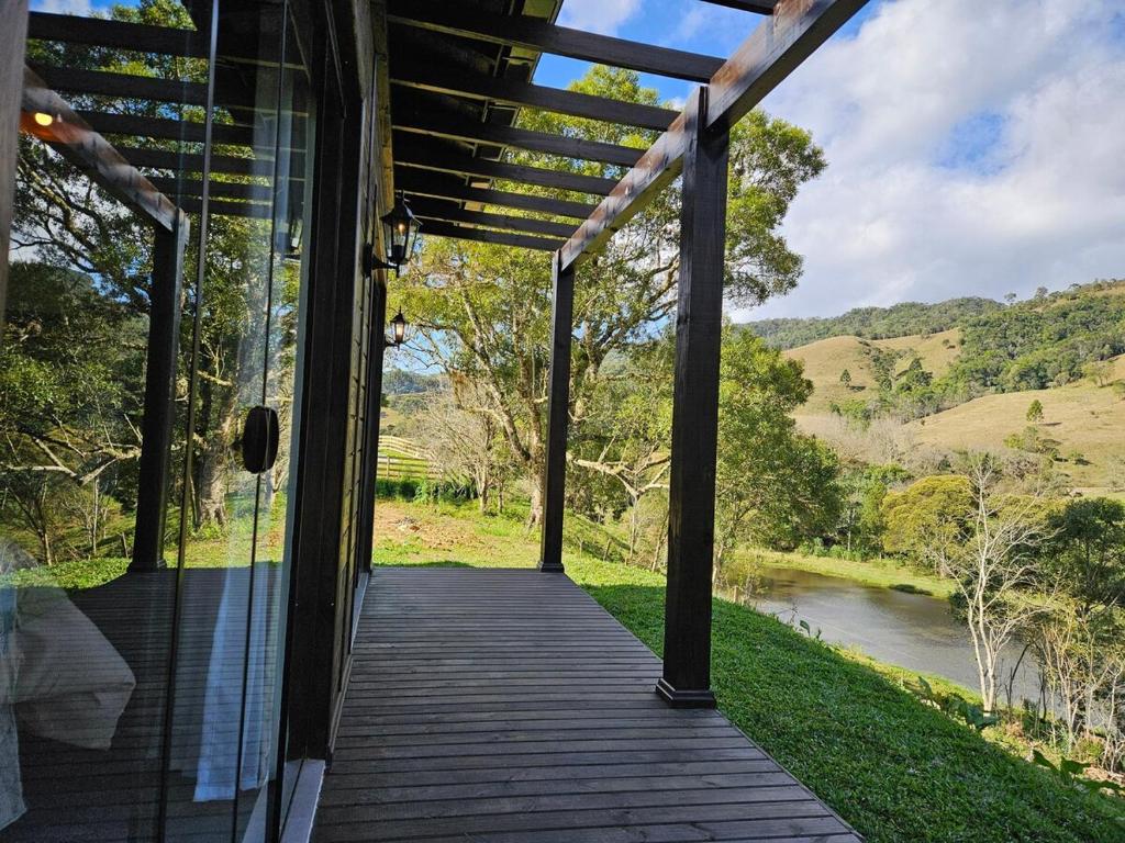 a porch of a house with a view of a river at Rio Acima Perfect Housing Rancho Queimado in Rancho Queimado