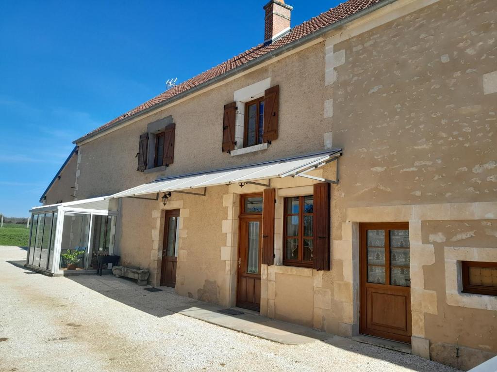 a building with a white awning on the side of it at La maison Cécile 15/17 pers in Étais-la-Sauvin