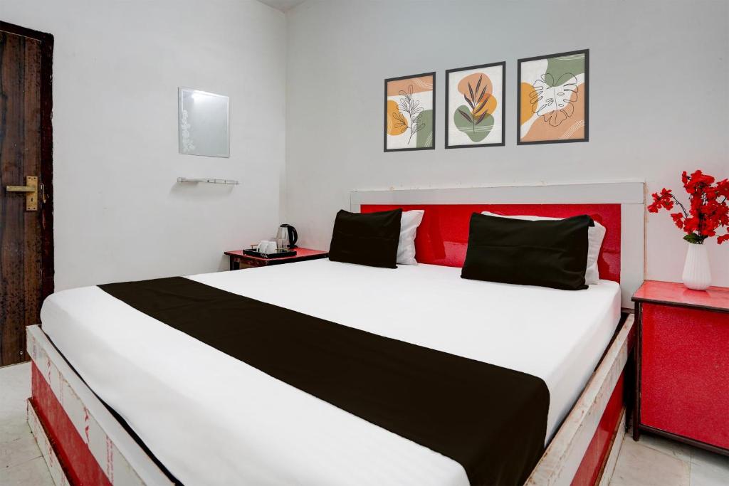 a bedroom with a large white bed with a red headboard at Hotel O The King Heaven in Bewar
