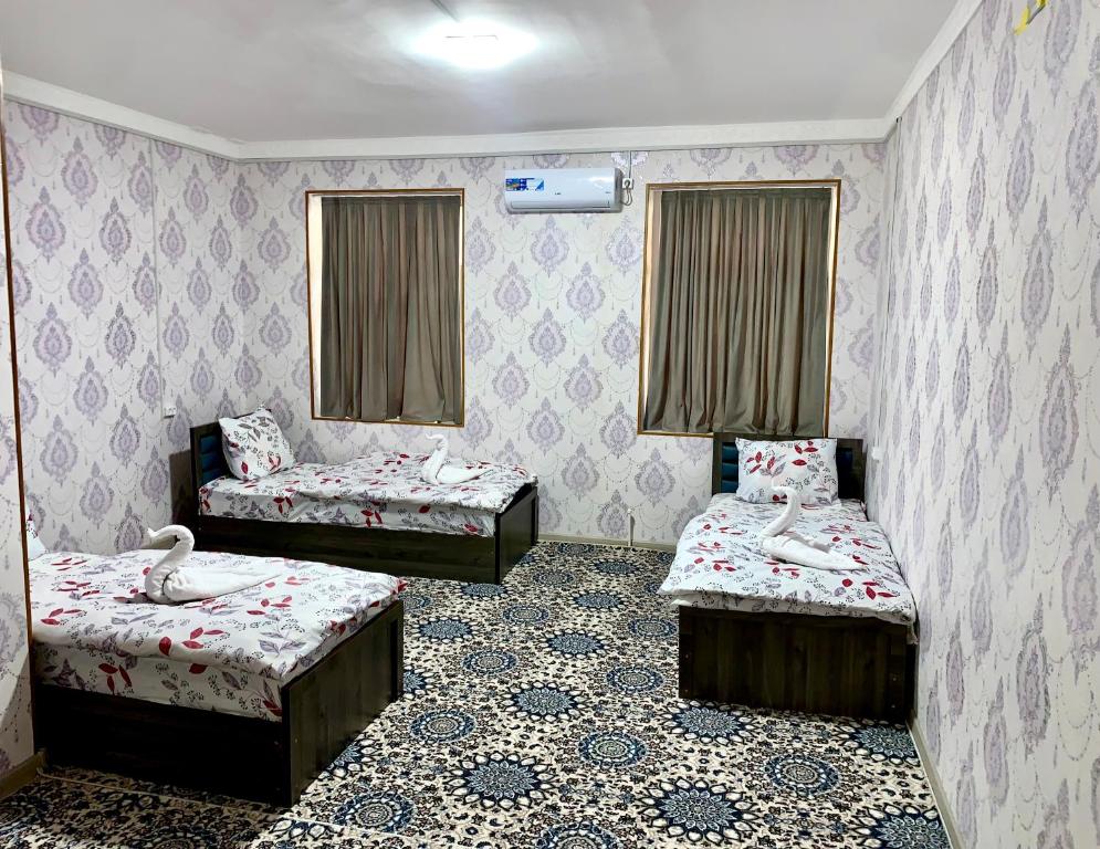 a room with two beds and two trunks at AsiaHotel in Kokand