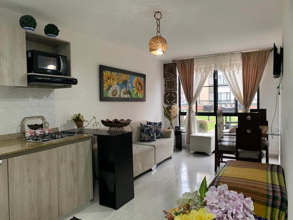 a kitchen and a living room with a couch at Descansa en el Mejor Club Residencial de Cartago in Cartago