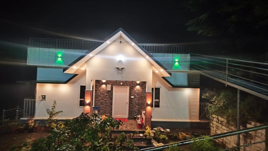 a house with green lights on it at night at Golden Villa in Vagamon