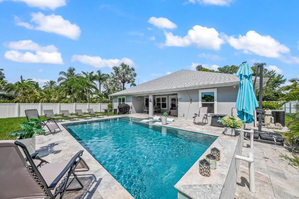 una piscina con sedie e ombrellone accanto a una casa di No Bad Daze a Palma Sola Park