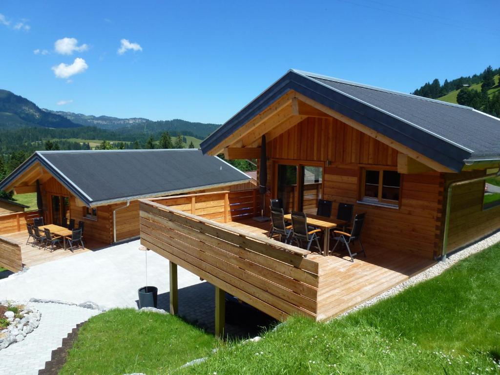 Blockhütte mit einer Terrasse und einem Tisch in der Unterkunft Walser Berg Chalets in Riezlern
