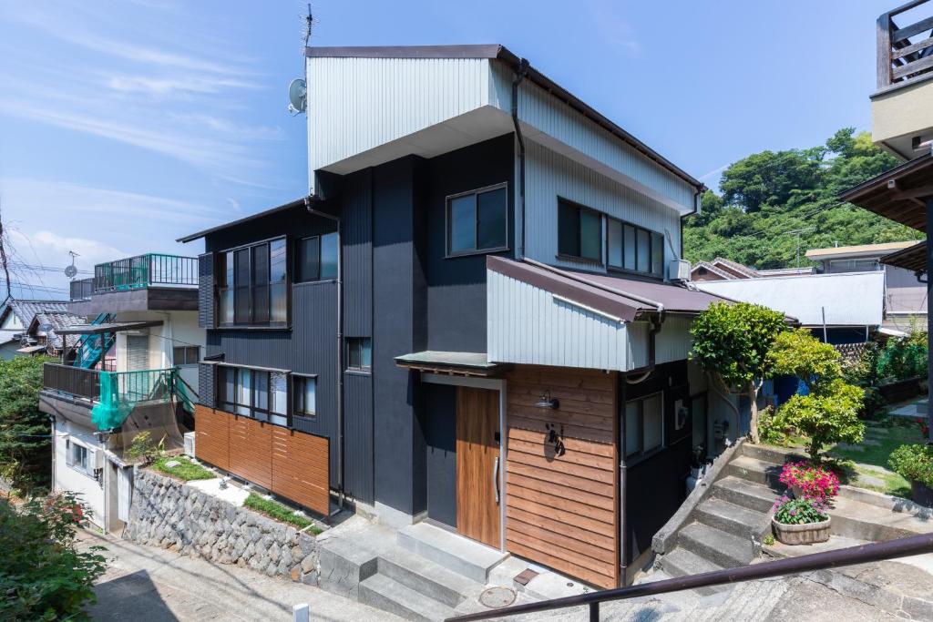 a house with a black and wooden exterior at 一棟貸し 小海の宿 いおり in Numazu