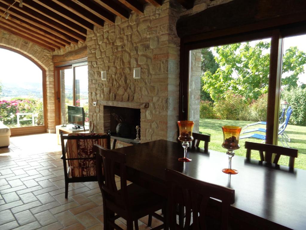 托迪Agriturismo La Torraccia的带桌子和壁炉的餐厅