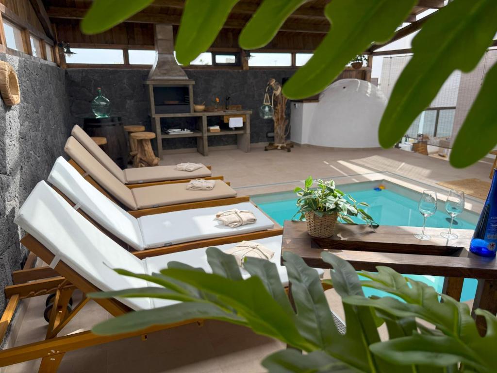 Una habitación con una cama y una piscina. en Casita Oyala, en San Bartolomé