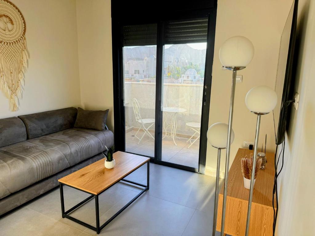 un salon avec un canapé et une table dans l'établissement סוויטת ארגמן, à Beʼer Ora