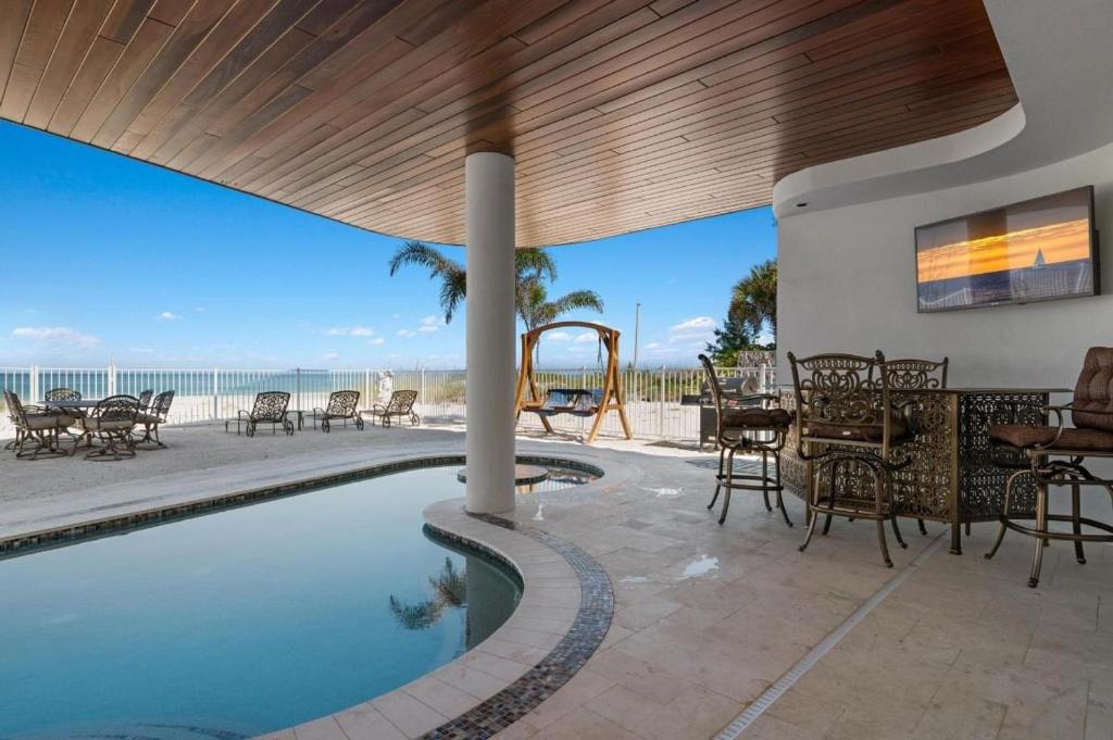 a house with a swimming pool with a table and chairs at Anna Maria Wave in Ilexhurst