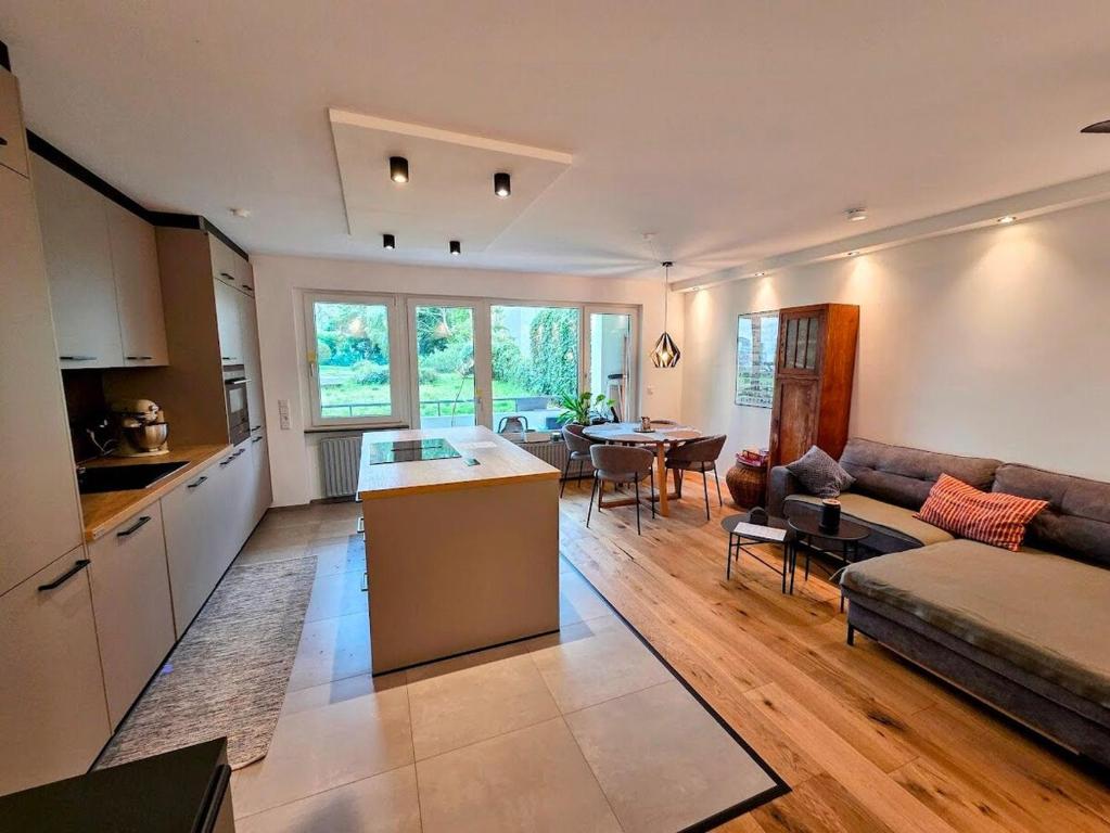a kitchen and living room with a couch and a table at Design-Wohnung im Zentrum mit Balkon und Parkplatz in Offenbach