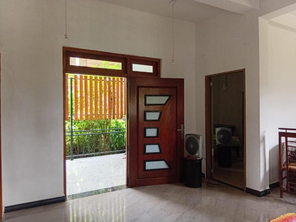 a room with a door with a window and a television at Gagana Villa in Kandy